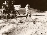 photographie en noir et blanc d'un astronaute sur la Lune, à côté d'un panneau