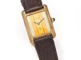 an image of a gold plated wrist watch with a brown leather strap