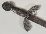 a silver sword with a black handle on a white surface