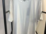 un t-shirt blanc suspendu à un portant dans une pièce