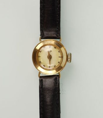 gros plan d'une montre sur une surface blanche avec un bracelet noir