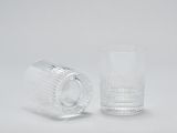 un verre transparent avec une anse à côté d'un verre transparent avec une anse