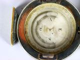 a close up view of a pocket watch on a white surface
