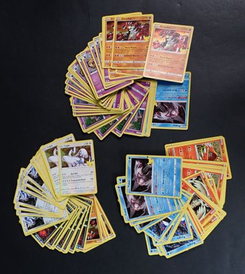 plusieurs cartes Pokémon posées sur une table avec un fond noir