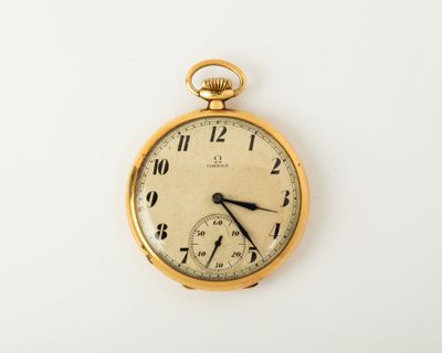 a gold pocket watch on a white surface