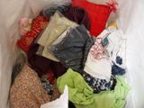 a white bag filled with clothes and a pillow