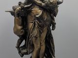 statue en bronze d'une femme tenant un oiseau sur un piédestal
