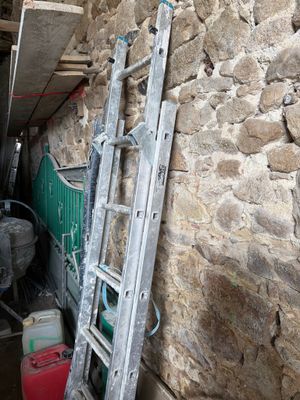 une échelle appuyée contre un mur de pierre dans une pièce