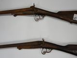 two old guns are displayed on a wall in a room