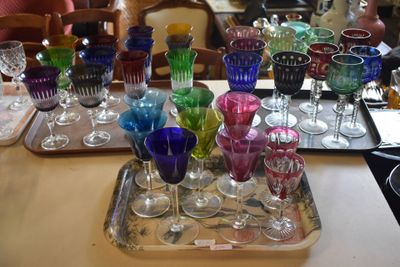 many different colored glasses on a tray on a table