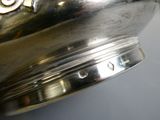 a close up of a silver bowl with a gold emblem