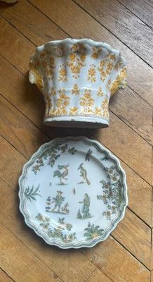 two plates and a bowl sitting on a wooden floor