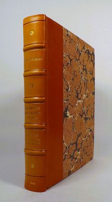 an orange book sitting on top of a white table next to a white wall