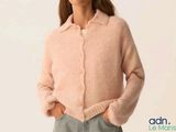 a picture of a woman wearing a pink sweater and jeans