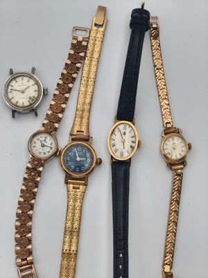 quatre modèles différents de montres-bracelets posés sur un fond blanc