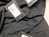 three tags on the back of a black jacket