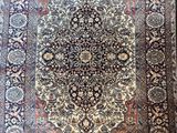 an antique persian rug with a medallion design on a wooden floor