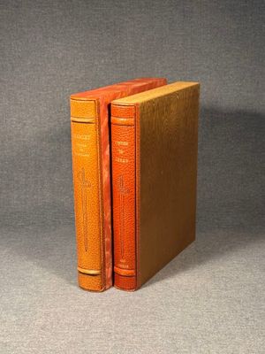 two orange books sitting on top of each other on a table