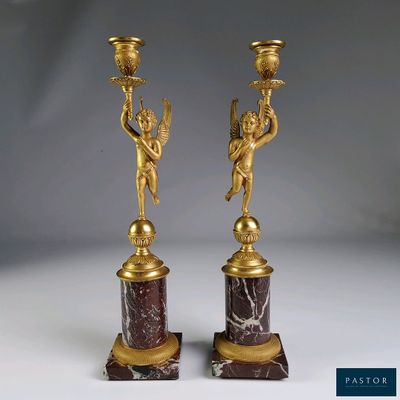 paire de bougeoirs anciens en bronze ornés de chérubins, sur des socles en marbre