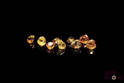 un gros plan sur un groupe de diamants jaunes posés sur une surface noire