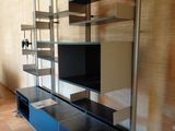 a television on a shelf in a room with tile flooring