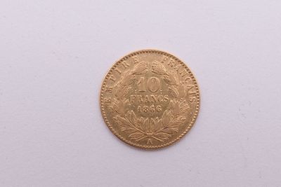 gros plan d'une pièce d'or sur une surface blanche