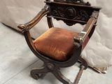 une vieille chaise en bois avec une assise rouge, posée sur un sol en béton
