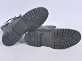 pair of black boots on a white surface with a white background