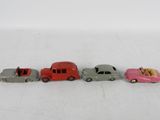 four toy cars are lined up in a row on a white surface