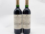 deux bouteilles de vin rouge posées l'une à côté de l'autre sur une surface blanche