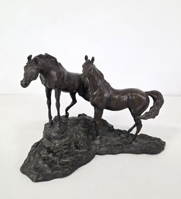 a statue of two horses standing on top of a rock