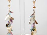 two pairs of earrings on a clear stand with a white background