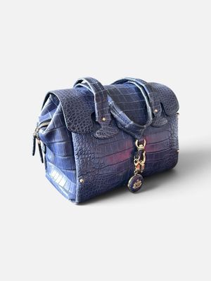 sac à main à carreaux violets et bleus sur fond blanc, avec des découpes