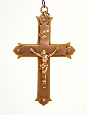 une croix sur laquelle est suspendu un crucifix, le tout accroché à une chaîne