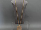 a gold necklace with a square pendant on a mannequin