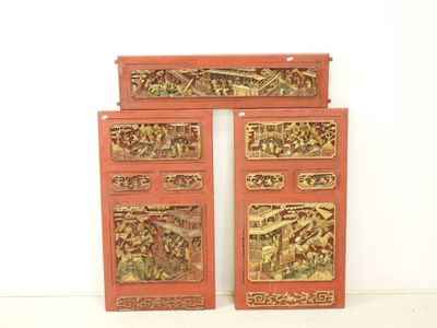 deux portes rouges ornées de sculptures dans une pièce