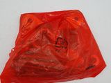 un sac rouge rempli de nourriture posé sur une surface blanche