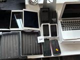 several laptops, phones, and tablets are sitting on a table