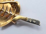 a gold plated fork and a knife on a white surface