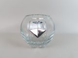 a glass vase with a silver object inside of it