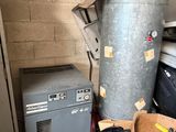 un tas de vieilleries dans un garage, à côté d'un chauffe-eau