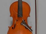 un vieux violon avec un archet et une repose-archet posé sur une table