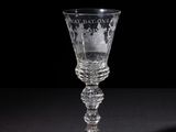 a wine glass sitting on a table with a black background