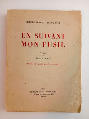 un vieux livre posé sur une table blanche, avec une couverture rouge