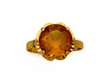 un gros plan sur une bague en or sertie d'une grosse citrine