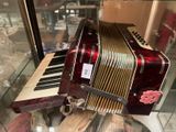 a red and white accordion on display in a glass case