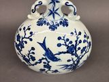 un vase bleu et blanc avec un oiseau dessus