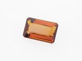 une tourmaline orange posée sur un fond blanc