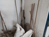 a pile of brooms and a bag in the corner of a room