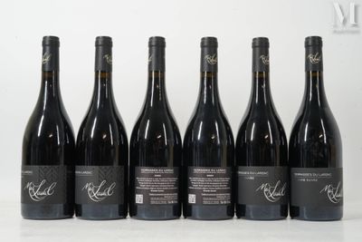 six bottles of red wine are lined up on a table